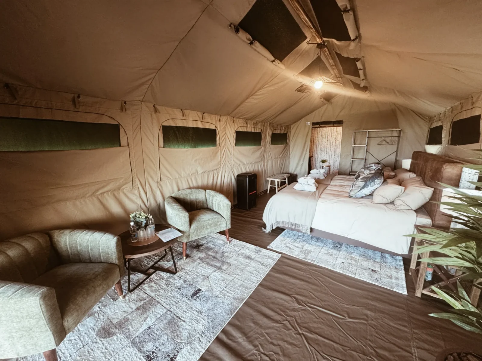 Lounge seating and sleeping area inside a luxury safari tent